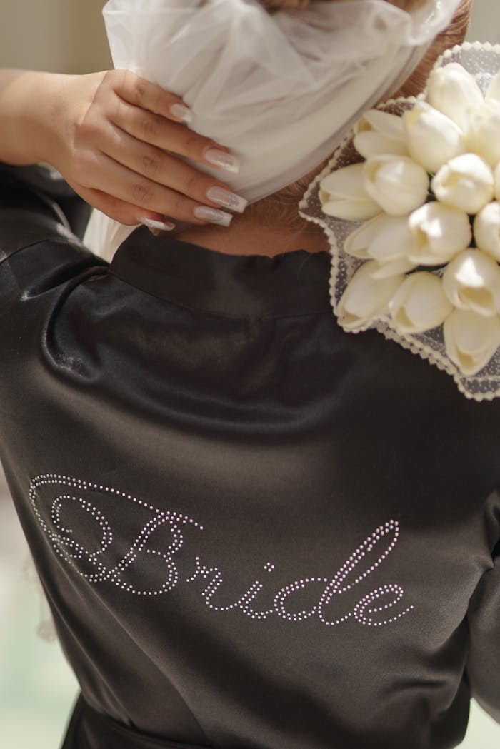 A wedding scene showcasing a bride in an embellished robe holding a bouquet of white tulips.